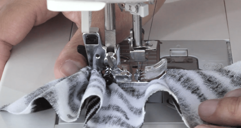 Put your finger or thumb behind the presser foot to ease the fabric.