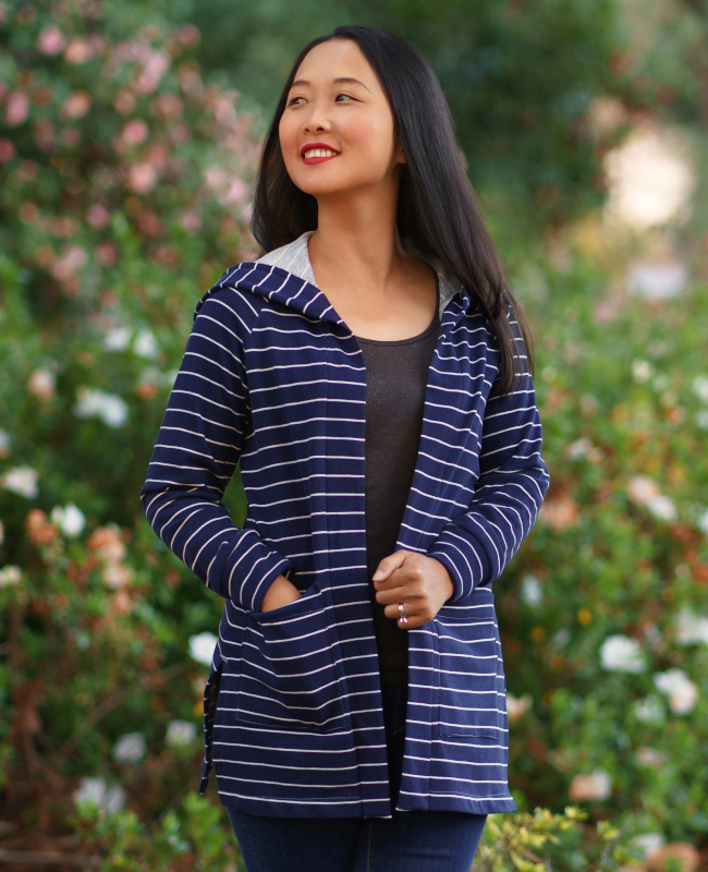 Model wears a long line cardigan with a hood made from blue and white striped jersey